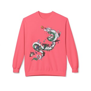 May include: Coral-colored sweatshirt featuring a detailed illustration of a white dragon with green accents, surrounded by animated characters. The design is centered on the front of the long-sleeved top.