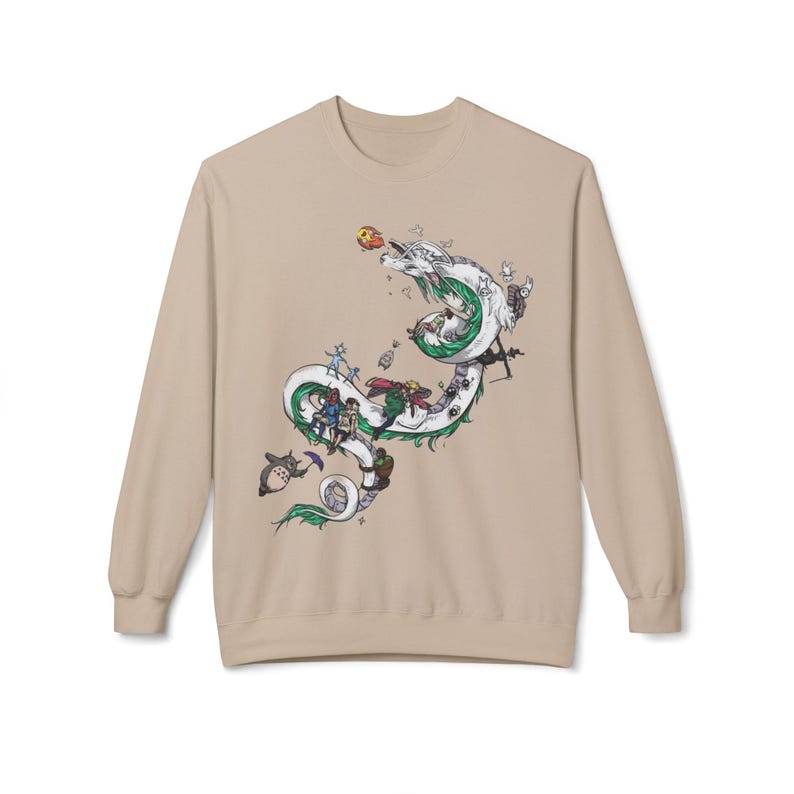 May include: Beige long-sleeve sweatshirt featuring a detailed illustration of a white dragon with green accents, carrying various animated characters. The design includes a mix of colors and cartoon elements, creating a whimsical aesthetic.