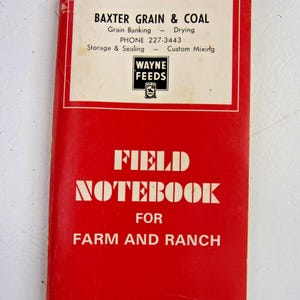 May include: A red field notebook with white text that reads "FIELD NOTEBOOK FOR FARM AND RANCH." The top of the notebook has a white rectangle with the text "BAXTER GRAIN & COAL" and "WAYNE FEEDS" logo.