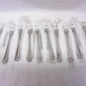 May include: A collection of Farberware forks, individually wrapped in clear plastic. The forks are silver-colored with a decorative floral design on the handle. The Farberware logo is printed on the packaging.