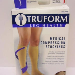 May include: A white cardboard box for Truform Leg Health medical compression stockings. The packaging features beige open-toe below-knee stockings, 20-30 mmHg firm compression, size X-Large, and text detailing benefits for circulation and swelling.