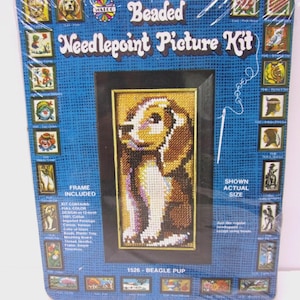May include: A beaded needlepoint picture kit featuring a Beagle pup. The kit includes a frame and contains a full-color design on 12-mesh canvas. The packaging is blue with the text "Beaded Needlepoint Picture Kit" and "1526 - Beagle Pup".