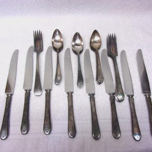 May include: A white ceramic mug with a black handle and the text "But First, Coffee" in a black, bold font. The mug is on a white surface.