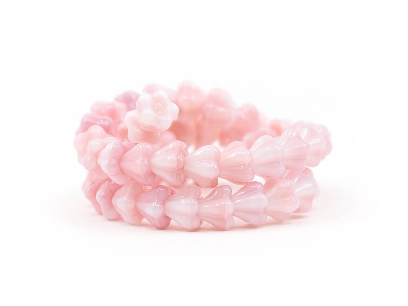K&ouml;nnte beinhalten: Eine Str&auml;hne aus rosa Glasperlen mit einem bl&uuml;tenf&ouml;rmigen Design. Die Perlen sind kreisf&ouml;rmig angeordnet und erzeugen einen zarten und femininen Look.