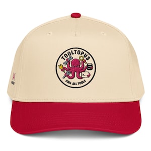 May include: A cream-colored baseball cap with a red brim and a red button on top. The front features an embroidered circular patch depicting a pink octopus holding various tools, with the text TOOLTOPUS and CALL ALL TOOLS in black.