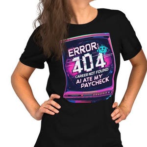 May include: Black t-shirts featuring a graphic with the text "ERROR: 404 CAREER NOT FOUND AI ATE MY PAYCHECK." The design is a retro computer screen with pink, blue, and green colours. Two people are wearing the shirts.