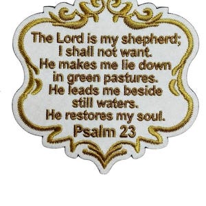 May include: A white embroidered patch with a gold scalloped border featuring the text: The Lord is my shepherd; I shall not want. He makes me lie down in green pastures. He leads me beside still waters. He restores my soul. Psalm 23.