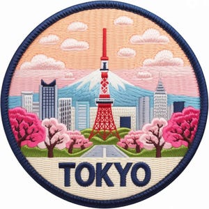 May include: A circular embroidered patch featuring a cityscape of Tokyo with the Tokyo Tower in the center, a mountain in the background, and pink cherry blossom trees in the foreground. The word TOKYO is stitched in dark blue at the bottom.