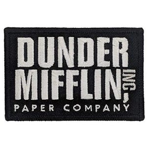 May include: A rectangular black embroidered patch featuring the white text DUNDER MIFFLIN PAPER COMPANY. The design is oriented horizontally with a thick black border and a textured fabric finish, displaying the company name in a bold, sans-serif font.