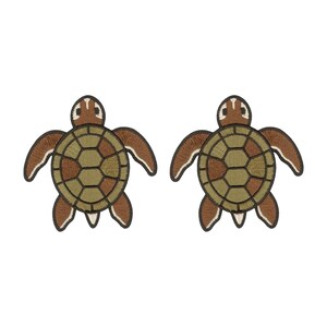 May include: Two identical embroidered patches shaped like sea turtles. Each turtle features a brown head with white markings, brown flippers, and a circular shell with a geometric pattern in shades of olive green and brown, all outlined in dark brown.
