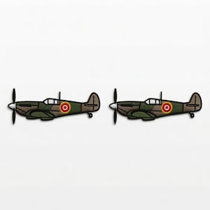 May include: Two identical embroidered patches shaped like vintage fighter airplanes. Each patch features a camouflage pattern in shades of olive green and brown, a black propeller, a cockpit window, and a circular red, yellow, and white emblem.