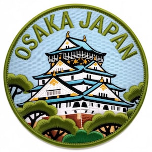 May include: Embroidered patch featuring Osaka Castle in Japan. The patch has a light blue background with the words "OSAKA JAPAN" in green. The castle is white with blue and gold accents, surrounded by green trees.