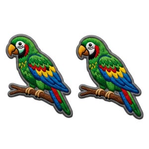 Può includere: Due toppe ricamate identiche raffiguranti un pappagallo verde con piume alari gialle, blu e rosse appollaiato su un ramo marrone. Il pappagallo ha un becco giallo, una macchia bianca sul viso e un bordo nero attorno al design.