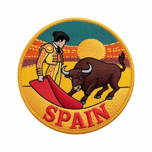 May include: A circular embroidered patch featuring a matador in a yellow suit holding a red cape toward a brown bull. The background shows a yellow sun over a landscape with teal and orange sky. The word SPAIN is stitched in red at the bottom.