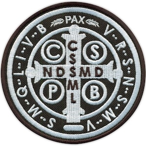 Pode incluir: Um emblema bordado circular com fundo castanho escuro, uma cruz branca e motivos circulares. O design inclui as letras C S P B, N D S M D e o texto PAX ao longo da borda superior, rodeado por uma borda de letras em fio branco.