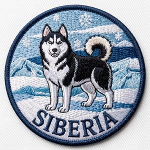 May include: A circular embroidered patch featuring a black and white Siberian Husky standing in a snowy mountain landscape with falling snowflakes. The word SIBERIA is stitched in dark blue capital letters along the bottom edge of the patch.