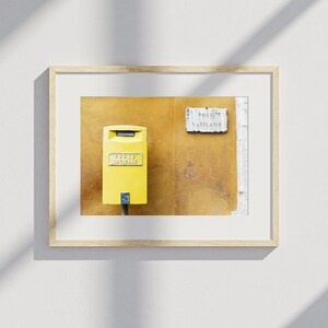May include: Framed print featuring a yellow postbox with the text "Poste Vaticane" and a sign that reads "Poste Vaticane". The postbox is mounted on a textured, ochre-colored wall.