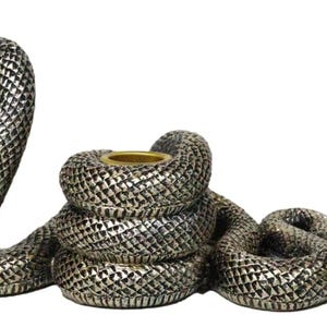 K&ouml;nnte beinhalten: Ein silberfarbener, schlangenf&ouml;rmiger Kerzenhalter. Der K&ouml;rper der Schlange ist gewunden, mit erhobenem Kopf und einem goldfarbenen Kerzenhalter in der Mitte. Die Schlange hat ein strukturiertes, schuppenartiges Muster.