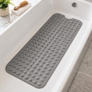 May include: A rectangular gray bathtub mat featuring a repeating pattern of raised circular suction cups and small drainage holes throughout the surface, designed to fit along the bottom of a standard white porcelain bathtub basin.