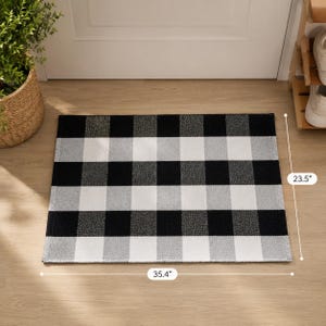 May include: A rectangular floor mat featuring a black, white, and gray buffalo check pattern. The mat measures 35.4 inches in width and 23.5 inches in height as indicated by the visible measurement labels on the image.