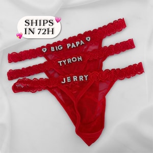 May include: Three red thong underwear with lace trim. The names "BIG PAPA", "TYRON", and "JERRY" are spelled out in silver letters across the front. The text "SHIPS IN 72H" is in a white oval.
