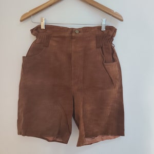 May include: Brown suede shorts with a high waist and two front pockets.