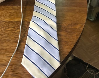 May include: A striped tie with blue and cream stripes. The tie is made of a silky fabric.