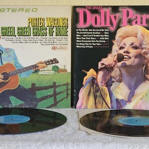 May include: Two vintage vinyl records. One album cover features Porter Wagoner with the text "Green, Green Grass of Home." The other album cover features Dolly Parton with the text "The Great Dolly Parton Vol. 2."