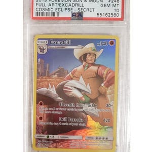 May include: A graded Pokémon card featuring Excadrill from the Sun & Moon Cosmic Eclipse set. The card displays a character in a cowboy hat with a drill-like weapon. The card is encased in a protective holder with the text "2019 Pokemon Sun & Moon" and "Gem MT 10".