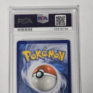 May include: A graded Pok&eacute;mon trading card encased in a clear plastic holder. The holder has a PSA label with a barcode and serial number. The card's back features the Pok&eacute;mon logo and a Pok&eacute; Ball design.
