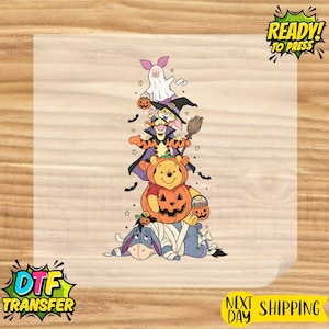 Op de afbeelding: Een DTF-transfervel met een verticale stapel Winnie de Poeh-personages in Halloween-kostuums. Knorretje is een spook, Teigetje draagt een cape, Poeh zit in een pompoen en Iejoor is als een mummie ingepakt. Inclusief vleermuizen en sterren.
