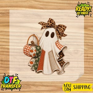 May include: A ghost-shaped graphic design featuring a patchwork pattern of orange, brown, and green fabrics. The ghost wears a leopard print bow and carries a pumpkin-shaped basket. The design includes various textures like gingham and floral prints.