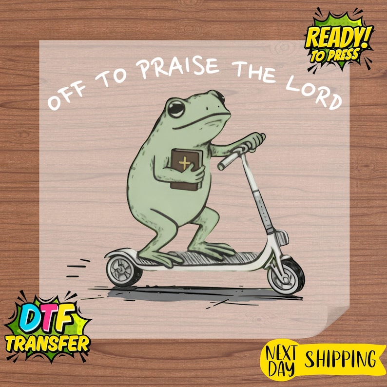 May include: A light green frog riding a white scooter, holding a book with a cross. The text "OFF TO PRAISE THE LORD" is arched above the frog. The image also includes "READY! TO PRESS" and "DTF TRANSFER" text.