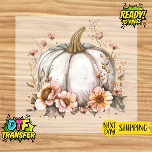 May include: A watercolor design featuring a white pumpkin with a tan stem, surrounded by peach and pink flowers and foliage. The image includes the text "READY! TO PRESS" and "DTF TRANSFER".