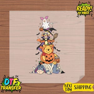 Op de afbeelding: Een warmteoverdrachtssticker met een verticale stapel stripfiguren verkleed voor Halloween. Knorretje is een spook, Konijn draagt een heksenhoed, Teigetje een cape, Winnie de Poeh zit in een pompoen en Iejoor is als een mummie ingewikkeld.