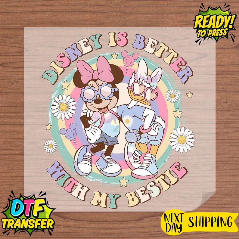 May include: A colorful DTF transfer featuring Minnie Mouse and Daisy Duck with the text "Disney is Better With My Bestie." The design includes a rainbow background, daisies, and stars. The words "Ready to Press" and "Next Day Shipping" are also visible.