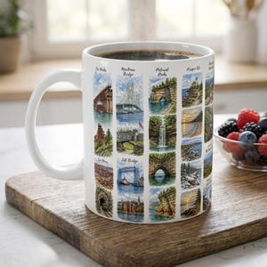 May include: A white ceramic mug featuring a grid of watercolor-style illustrations depicting various Michigan landmarks, including the Mackinac Bridge, Pictured Rocks, and Iron Mines, with each scene labeled in black script text.