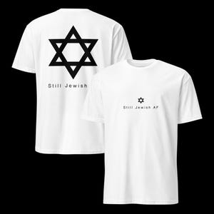 Könnte beinhalten: Weiße T-Shirts mit schwarzen Davidstern-Grafiken. Ein Shirt hat den Text "Still Jewish" auf dem Rücken. Das andere Shirt hat einen kleineren Davidstern und den Text "Still Jewish AF".