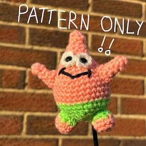 Könnte beinhalten: Handgehäkelter Patrick Star Plüsch in Rosa und Grün. Der Plüsch hat schwarze Augen und ein schwarzes Lächeln. Der Text "PATTERN ONLY" steht in Weiß über dem Plüsch.