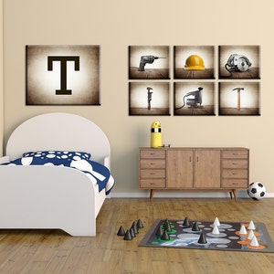 May include: A child's bedroom with a white bed, a wooden dresser, and a game on the floor. Wall art includes a large letter "T" and six images of tools. A soccer ball sits near the dresser. The room has a warm, inviting atmosphere.
