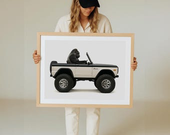 Impresión artística de un gorila conduciendo un Bronco 4x4 clásico: temática de safari