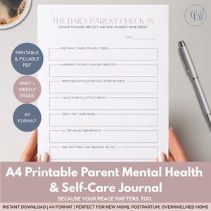 Peut inclure: Journal A4 imprimable pour la santé mentale et les soins personnels des parents. Le journal comprend des pages quotidiennes et hebdomadaires, et est remplissable au format PDF. Un stylo argenté repose sur le côté droit du journal.