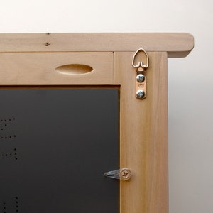 May include: A wooden frame with a black backing and a clear plastic latch. The frame has a metal hanging hook with two screws and the letters "A/S" on it.