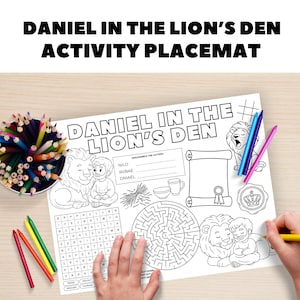 May include: A white activity placemat with the text "DANIEL IN THE LION'S DEN ACTIVITY PLACEMAT". The placemat features illustrations of lions, a boy, a maze, and word puzzles. Colored pencils and crayons are visible.