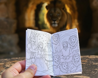 May include: A small, open book with black and white illustrations of people and lions is held in front of a blurred background of a lion in a cave. The book's pages depict scenes with figures and lions, creating a contrast between the detailed drawings and the natural setting.
