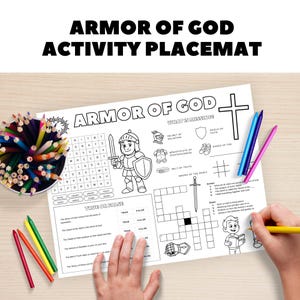 Op de afbeelding: Een zwart-wit activiteit placemat met de tekst "Armor of God" en een kruisafbeelding. De placemat bevat een woordzoeker, waar of niet waar vragen en een kruiswoordpuzzel. Kleurpotloden zitten in een beker.