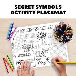 以下が含まれることがあります： 「SECRET SYMBOLS ACTIVITY PLACEMAT」の文字が入った白いアクティビティプレースマット。プレースマットにはクロスワードパズル、単語検索、さまざまなシンボルが掲載されています。色鉛筆とクレヨンが見えます。