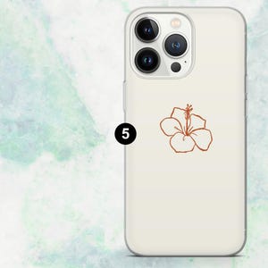 K&ouml;nnte beinhalten: Eine transparente Handyh&uuml;lle mit cremefarbenem Hintergrund und einem braunen Hibiskusbl&uuml;ten-Design. Die H&uuml;lle hat einen Kameraausschnitt und Tastenabdeckungen. Die Zahl "5" ist in Schwarz auf der linken Seite aufgedruckt.