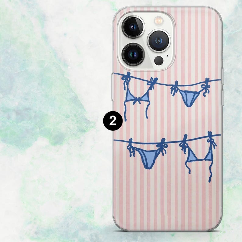 K&ouml;nnte beinhalten: Transparente Handyh&uuml;lle mit rosa-wei&szlig; gestreiftem Hintergrund. Die H&uuml;lle zeigt ein blaues Bikini-Design, das an einer W&auml;scheleine h&auml;ngt. Das Design wiederholt sich zweimal.