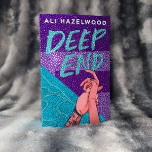May include: A book cover with the title "DEEP END" in turquoise lettering, and the author's name, "ALI HAZELWOOD", in white. The cover features a purple background with turquoise accents and an illustration of two hands holding each other.